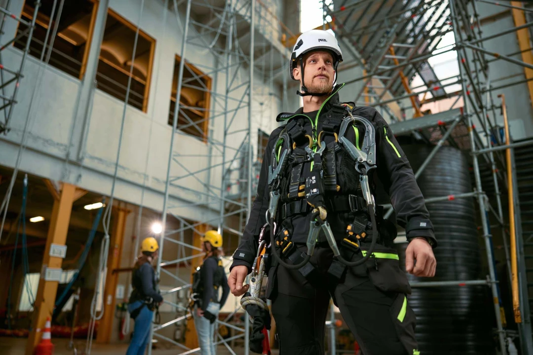 man met harnas aan en helm op poserend in hal