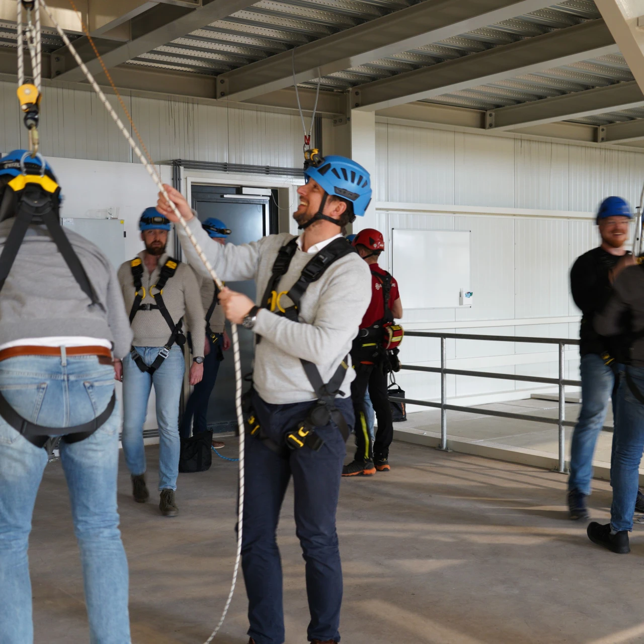 mannen die lachend in touwen hangen