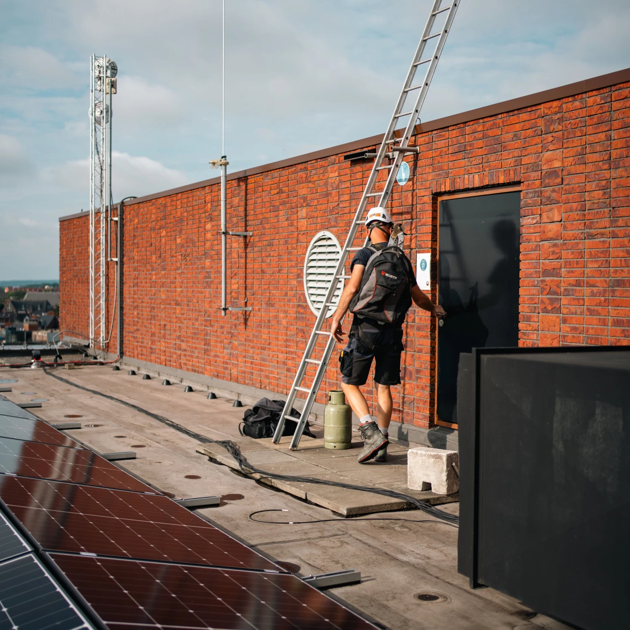 een mand ie op een dak loopt naast een ladder