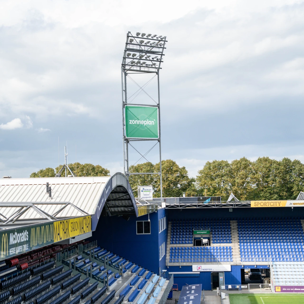 een mast met lampen bij een voetbalstadion