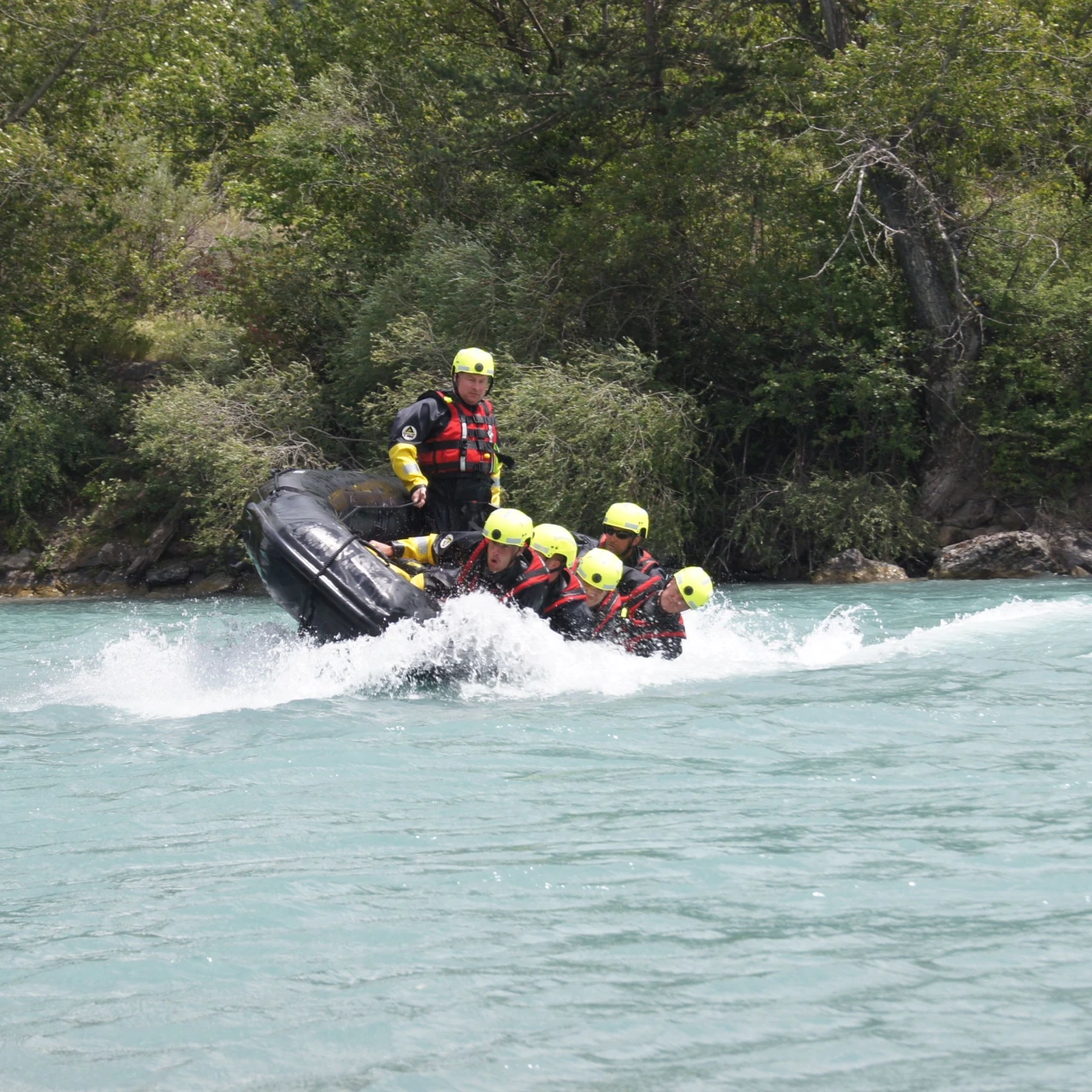 personen op boot op water met helm op en reddingsvest aan