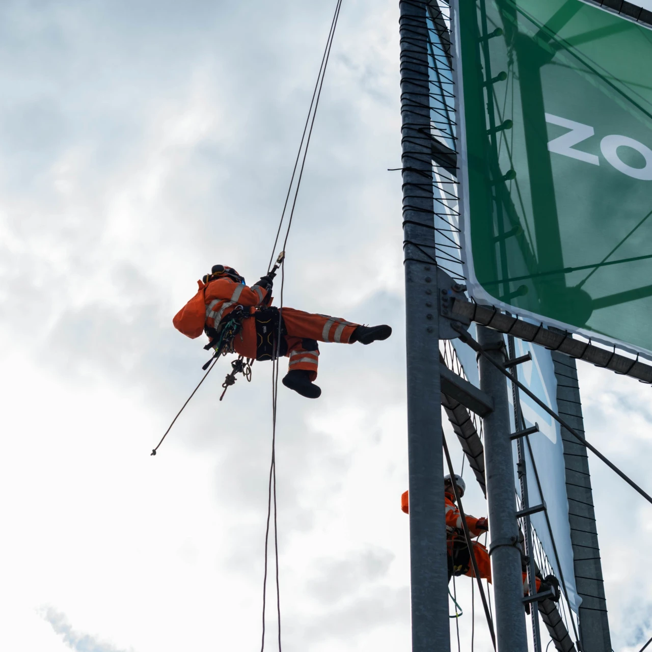 man die abseilt van een mast
