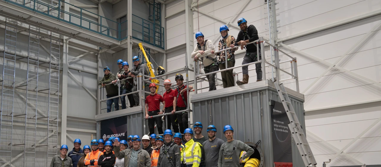 groepsfoto in trainingshal en ze hebben allemaal een helm op