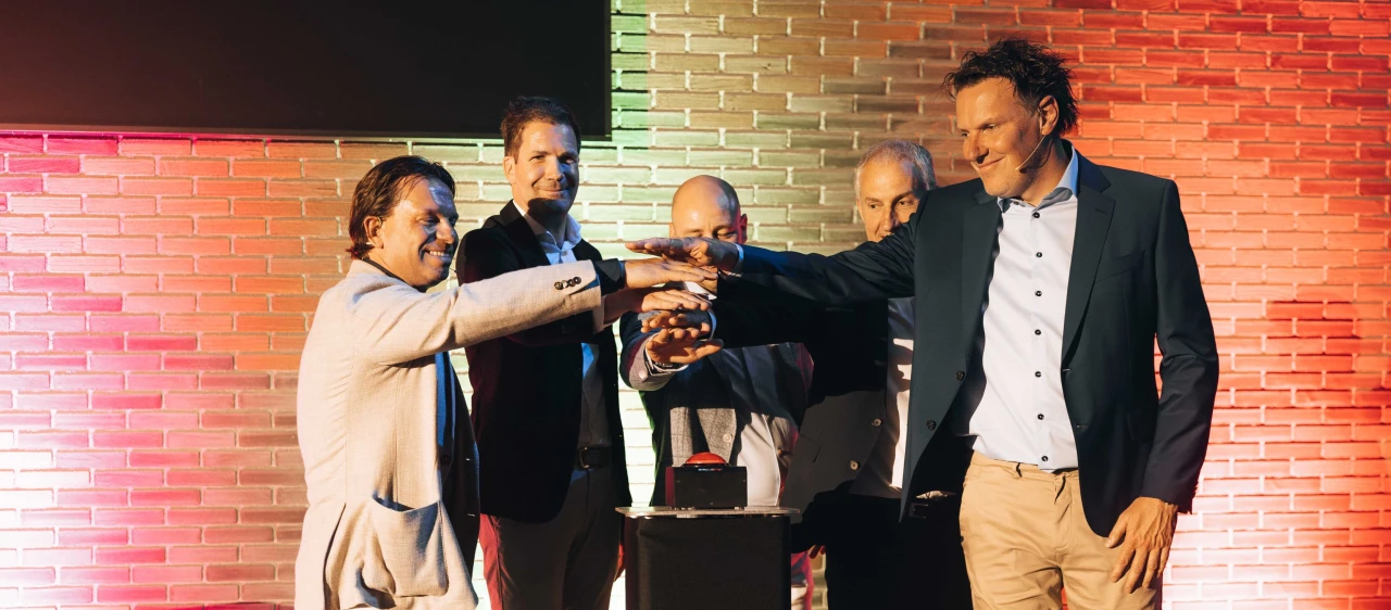 5 mannen bij de knop voor de opening van een pand