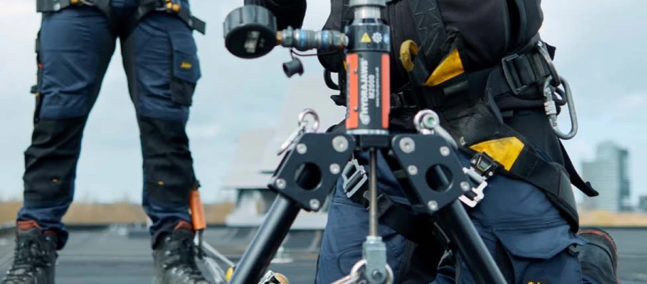 mannen op plat dak met harnas, helm en veiligheidsapparatuur