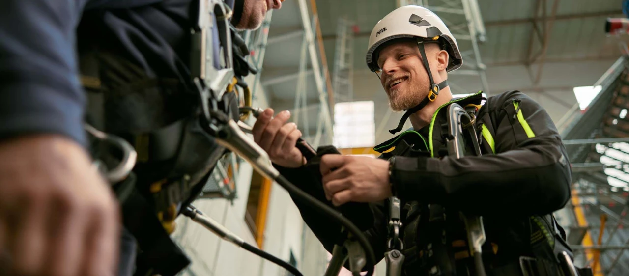 lachende mannen die elkaar helpen met harnas