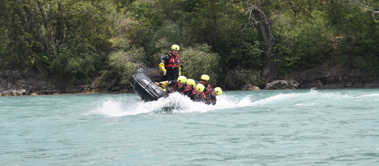 personen op boot op water met helm op en reddingsvest aan