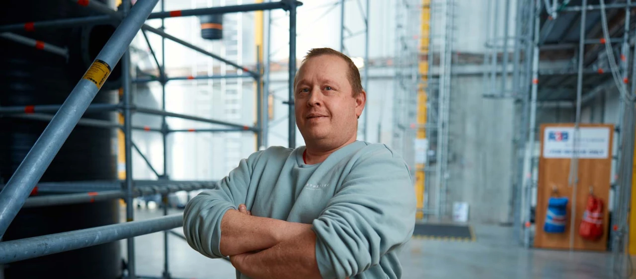 man met armen over elkaar in loods