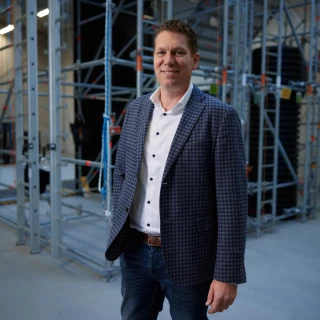 man met hand in zak in loods