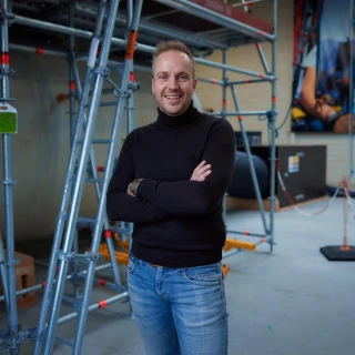 blije man poserend in hal