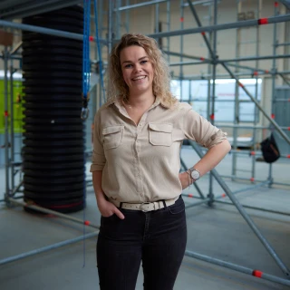 lachende vrouw met blonde krullen in loods