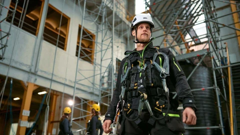 man in hal met harnas aan en helm op