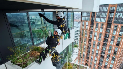 twee mannen met helm en harnas hangend aan dak