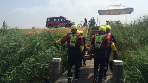 mannen die man helpen in brancard met helm op