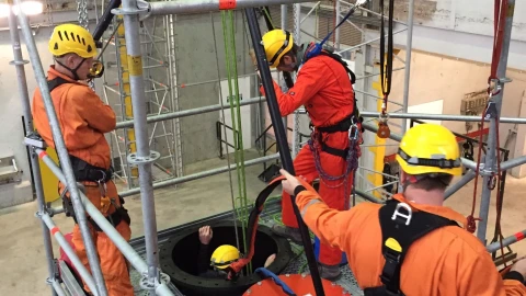 mannen in loods met helm en harnas en een man de besloten ruimte ingaat