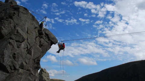 rots met touwen en man hangend aan touw
