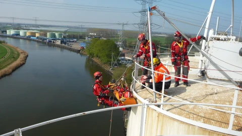 mannen op hoogte op dak met harnas en helm