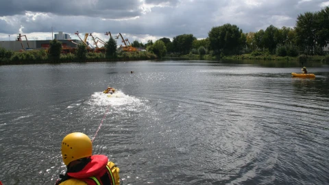 mensen met reddingsvest en bootje bij water