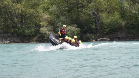 personen op boot op water met helm op en reddingsvest aan