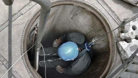Een man daalt af in een besloten ruimte, ook wel een riool