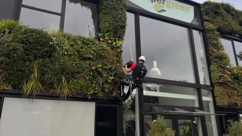 man hangend aan touw bij semper green gebouw
