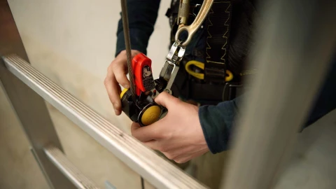 ladder met kabel en haak met man met harnas
