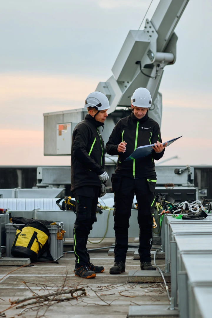 twee mannen op dak met harnas aan het overleggen