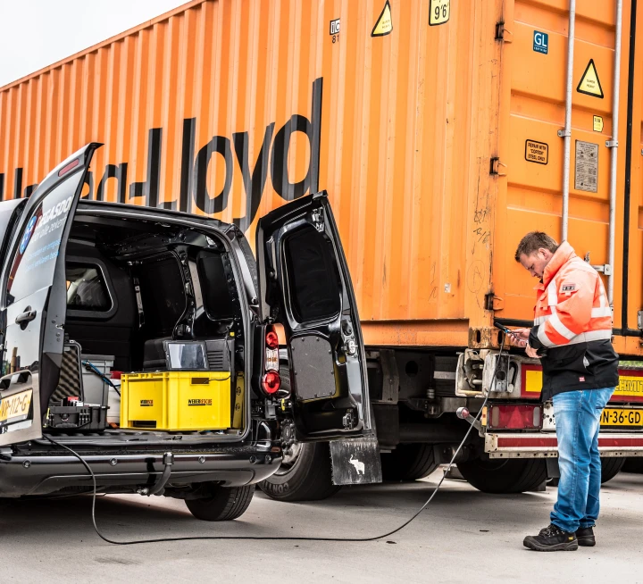man bij vrachtwagen bezig met kabel
