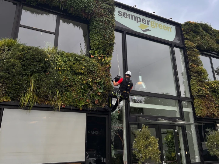 man hangend aan touw bij semper green gebouw